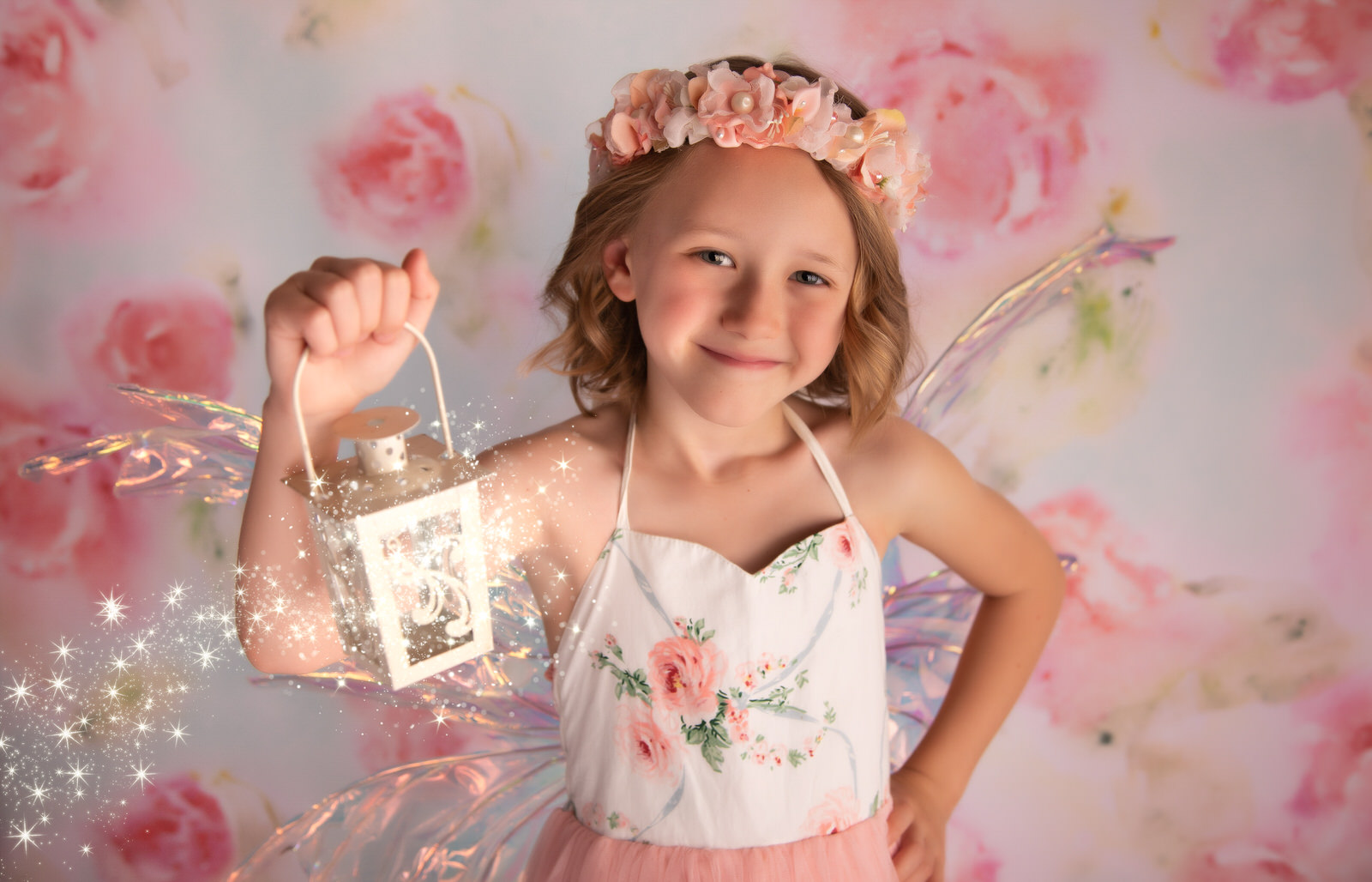 A young girl in a pink fairy costume holds a magical lantern in a studio DFW Kids