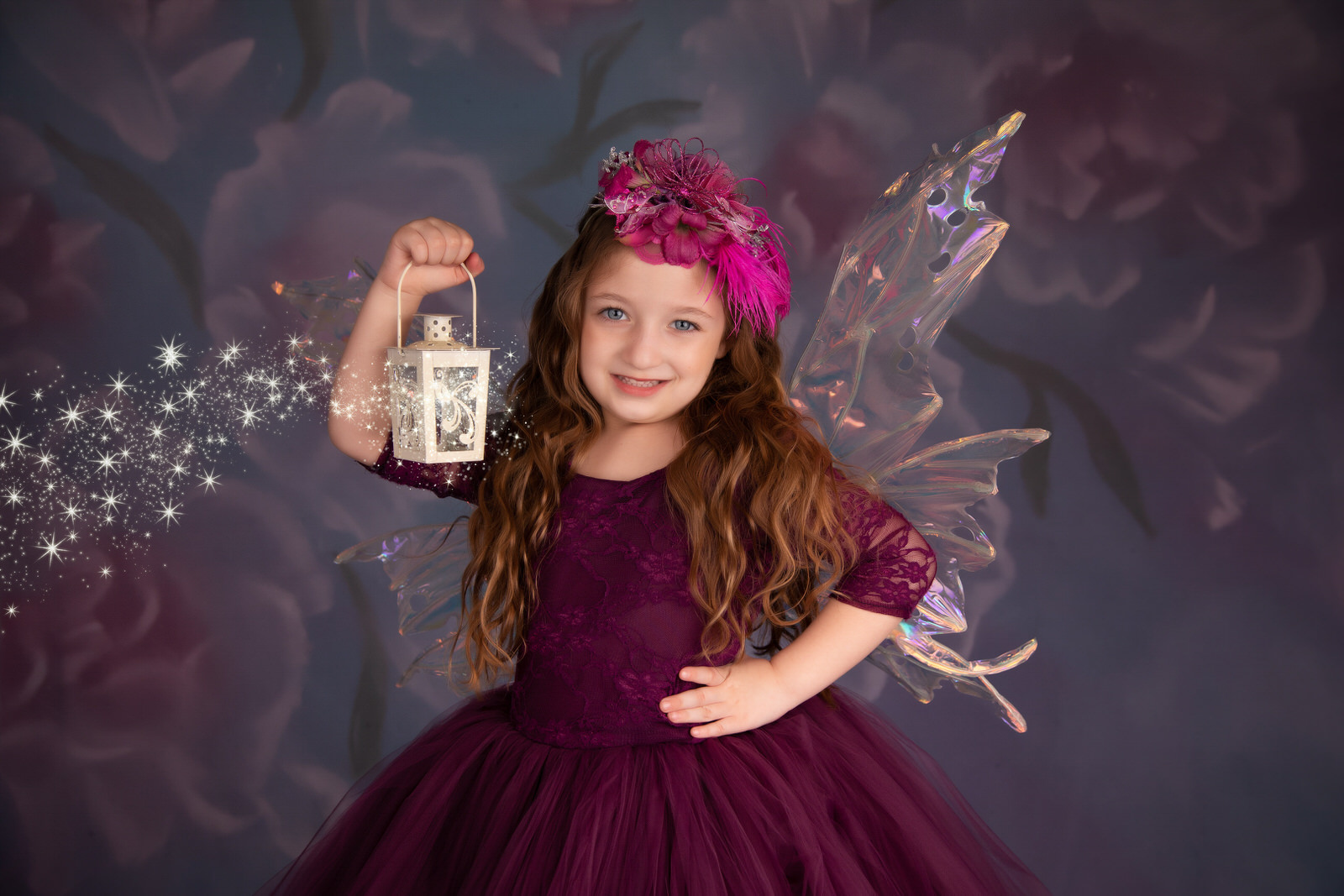 A young girl dressed as a purple fairy holds a magical lantern in a studio dallas pediatricians