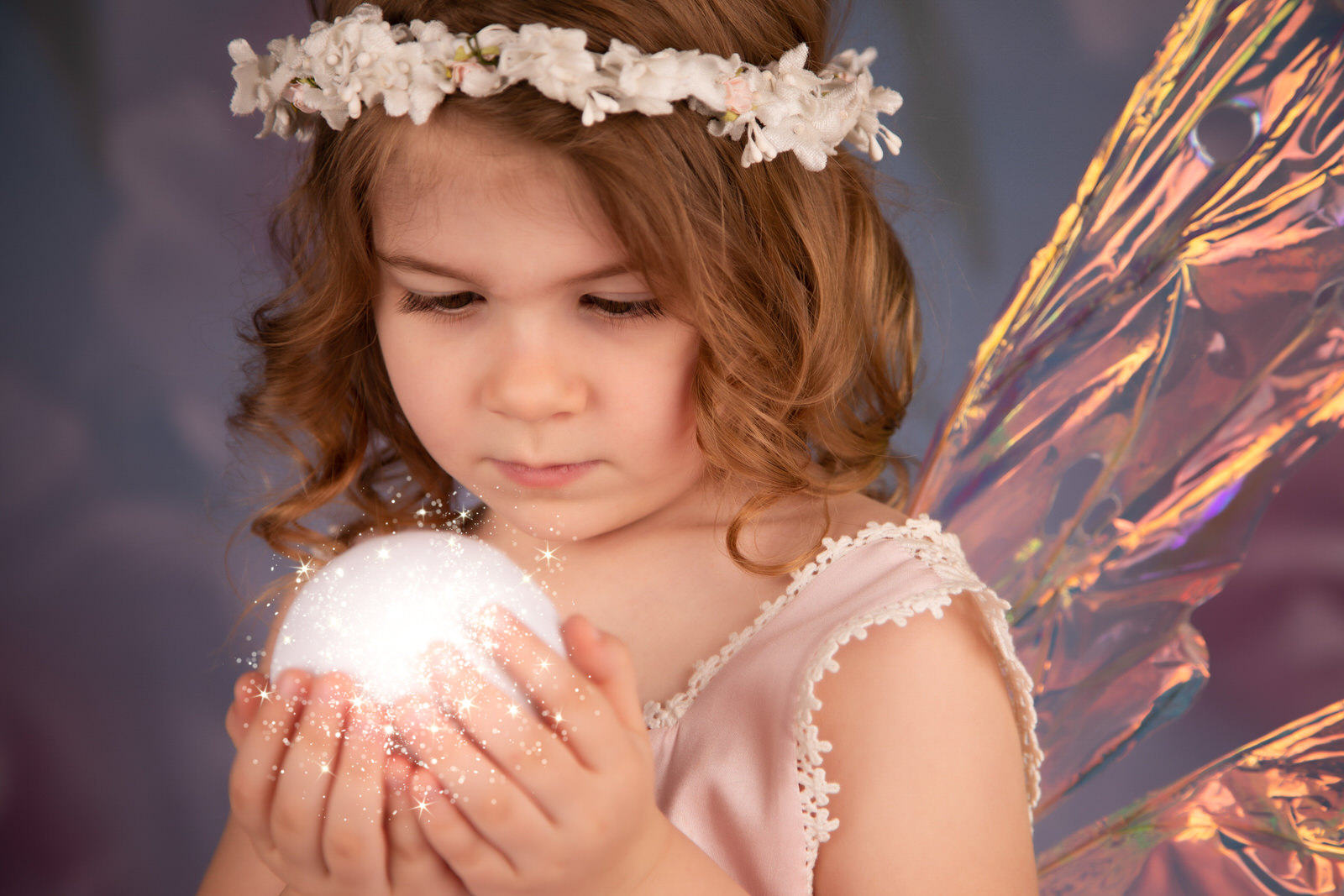 Girl dressed as a fairy holding a glowing orb for a fine art fairy photography experience